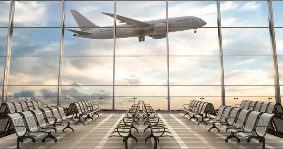 waiting area at airport with aeroplane seen flying from a distance