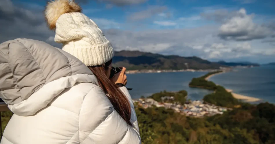Lady wearing a white jacket taking photos during winter holiday in South Africa